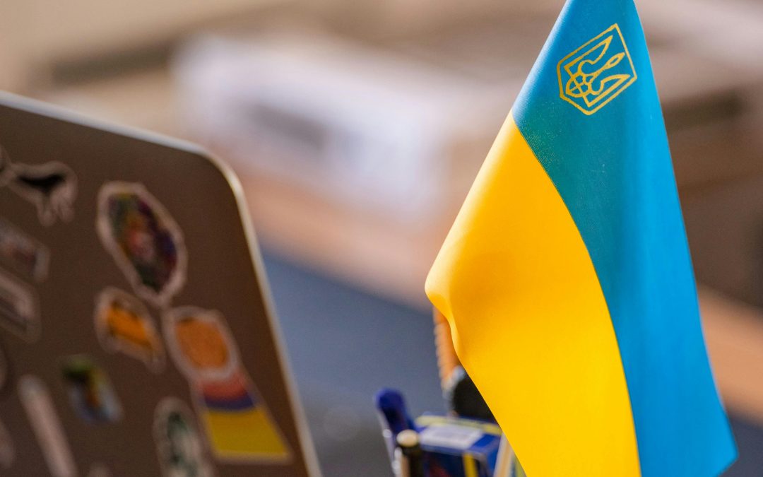 Ukrainian flag on a desk with a laptop